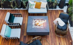 Patio en bois vu de haut avec chaises autour d'un foyer